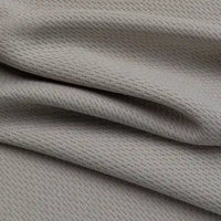 Gros plan sur le tissu piqué nid d'abeille au mètre de Longan Craft France, un tissu gris clair 100% polyester au motif gaufré subtil et aux plis souples, idéal pour les vêtements de sport DIY grâce à ses propriétés anti-humidité.