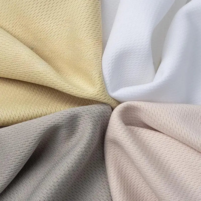Quatre pièces de Tissu piqué nid d'abeille au mètre de Longan Craft France en beige, blanc, gris et rose pâle sont disposées en cercle avec des centres qui se chevauchent. Ce tissu 100 % polyester présente un tissage diagonal subtil, idéal pour les projets de bricolage de vêtements de sport.