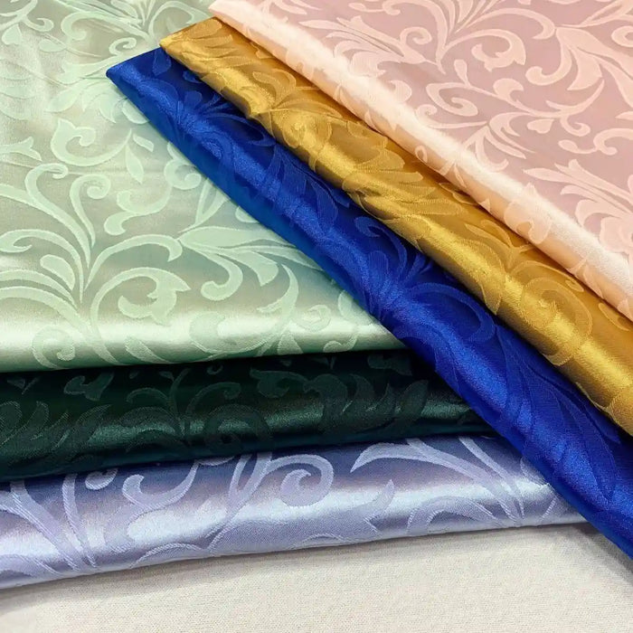 Six pièces pliées de Longan Craft France tissu damas brocart au mètre en rose, or, bleu, vert et violet clair présentent un motif floral jacquard brillant - idéal pour une décoration intérieure ou une robe de soirée.