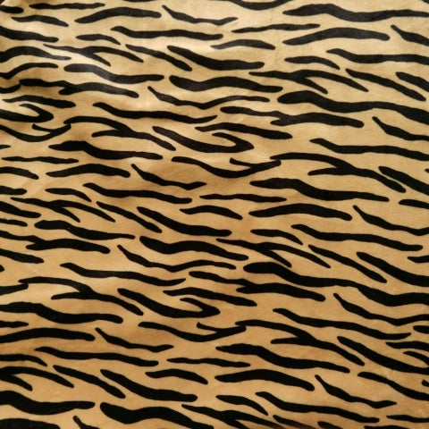 Gros plan sur le tissu minky à motif animalier au mètre de Longon Craft France, un polyester ultra-doux avec un motif animalier - léopard et vache - idéal pour les peluches.