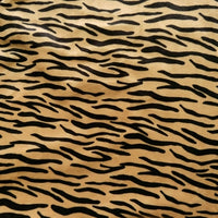 Gros plan sur le tissu minky à motif animalier au mètre de Longon Craft France, un polyester ultra-doux avec un motif animalier - léopard et vache - idéal pour les peluches.