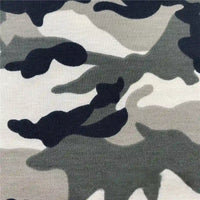 Gros plan sur le Tissu French Terry extensible imprimé camouflage au mètre de Longan Craft France, montrant des formes abstraites noires, grises et blanches qui se fondent les unes dans les autres - idéal pour les vêtements de sport respirants.