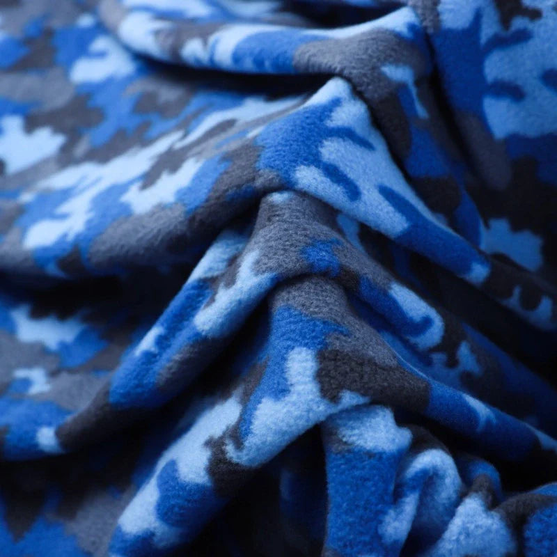 Gros plan sur le Tissu polaire camouflage au mètre de Longan Craft France, qui présente un motif brossé double face camouflage bleu, gris et noir, mettant en valeur la texture douce et les plis complexes du tissu pour les vêtements et la maison textile.