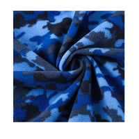Gros plan sur le tissu polaire camouflage au mètre, double face brossée, de Longan Craft France, torsadé pour mettre en valeur sa texture douce et ses variations de couleur en bleu clair, bleu foncé et noir pour le textile maison et vêtements.