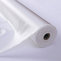 Gros plan sur le Tissu de soie charmeuse au mètre de Longan Craft France, déroulé pour révéler sa texture lisse et brillante de soie de mûrier, idéale pour les robes de mariée luxueuses.