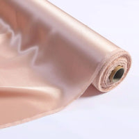 Un rouleau de Tissu de soie charmeuse au mètre, une soie de mûrier unie luxueuse pour robes de mariée de Longan Craft France, partiellement déroulé sur une surface blanche à la finition beige clair et brillante.