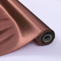 Gros plan sur le Tissu de soie charmeuse au mètre de Longan Craft France, un luxueux tissu de soie de mûrier en cuivre, partiellement déroulé sur une surface blanche pour montrer sa riche texture et sa brillance - idéal pour les robes de mariée.