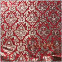 Un gros plan du tissu damassé chenille au mètre de Longan Craft France montre de luxueux motifs floraux jacquard en or et en argent, avec une texture légèrement surélevée et de douces rides qui mettent en valeur son élégant design de tapisserie damassée.