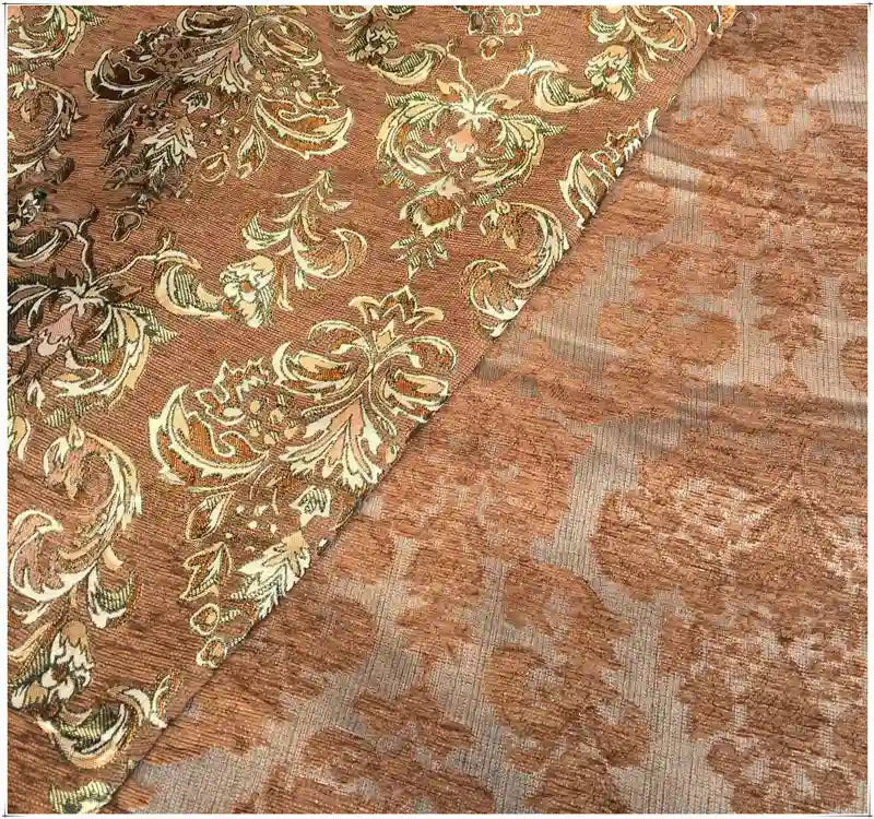 Chenille au mètre en tissu damassé de Longan Craft France, de couleur marron clair, avec des motifs jacquard floraux dorés, présentant un motif orné d'un côté et un revers plus subtil ; le tissu est présenté drapé ou partiellement plié.