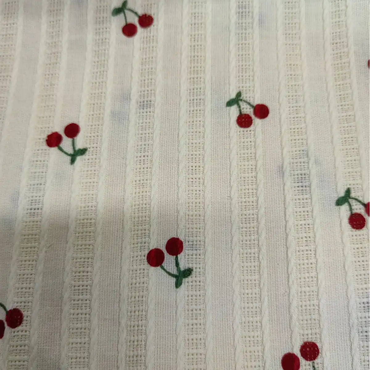 Tissu dobby rayé en coton blanc, imprimé de petites cerises rouges et vertes. Léger et confortable, idéal pour des créations originales d'été. Par Longan Craft France, vendu au mètre.