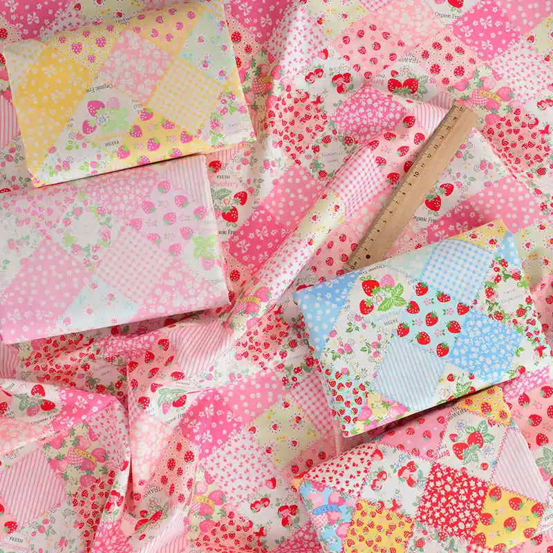 Le Tissu popeline imprimée effet patchwork multicolore au mètre de Longan Craft France présente des motifs floraux et de fraises, idéal pour les projets de patchwork et de vêtements - disponible au mètre.