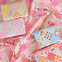Le Tissu popeline imprimée effet patchwork multicolore au mètre de Longan Craft France présente des motifs floraux et de fraises, idéal pour les projets de patchwork et de vêtements - disponible au mètre.
