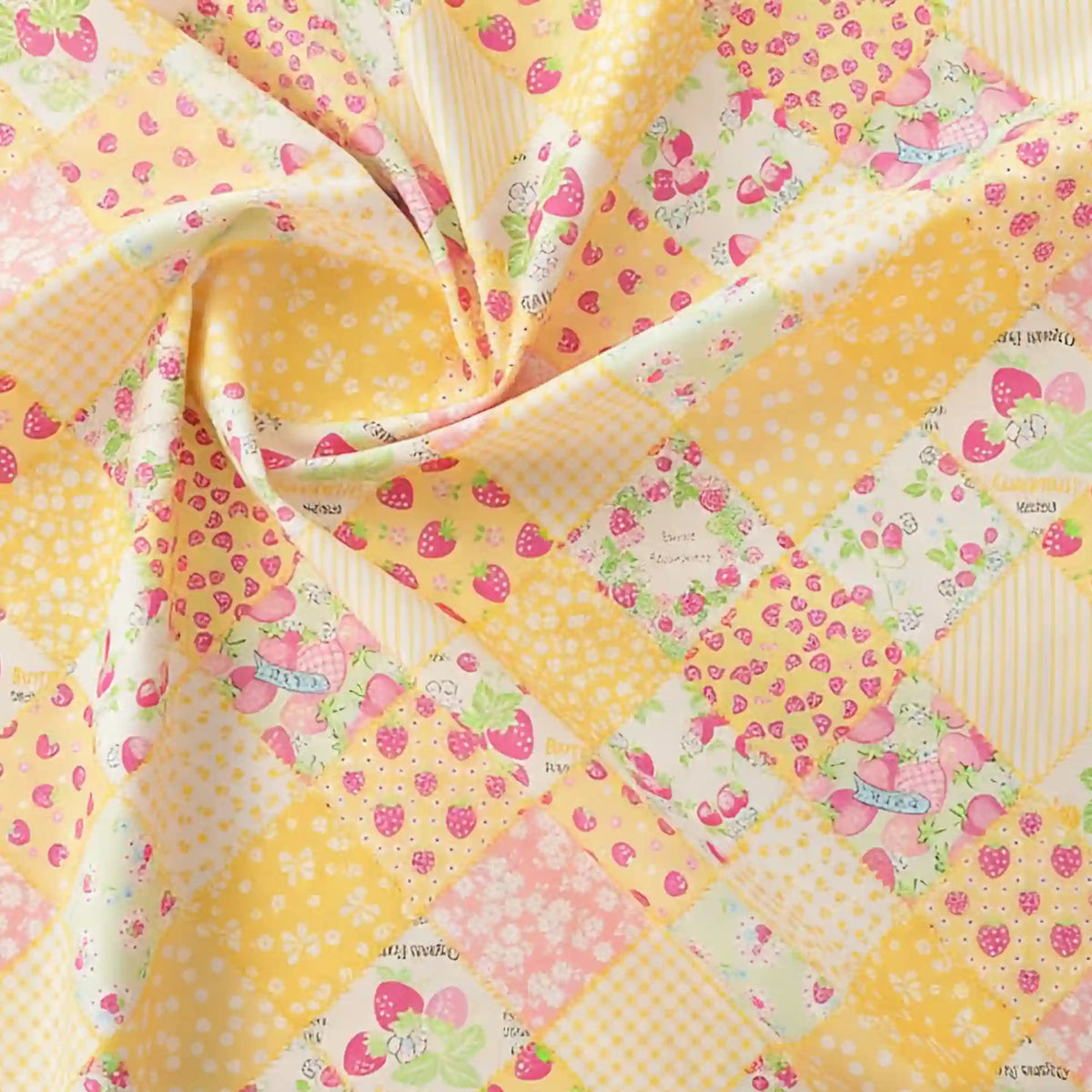 Un gros plan du tissu popeline imprimé effet patchwork multicolore de Longan Craft France montre des fraises, des vichy, des pois et des fleurs dans des tons pastel - idéal pour les projets de patchwork ou de couture créative.