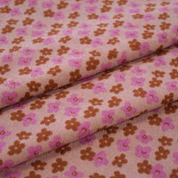 Tissu velours côtelé à fleurs colorées par Longan Craft France, idéal pour confection, ameublement et loisirs créatifs : motif floral marron et rose sur fond rose clair, motifs répartis uniformément sur le tissu.
