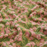 Un gros plan du Tissu velours côtelé à fleurs colorées de Longan Craft France montre un tissu doux et texturé avec un motif floral de fleurs roses et de feuilles vertes, idéal pour la couture, la décoration et l'artisanat.