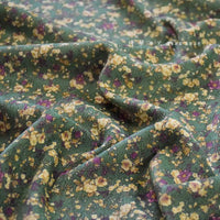 Découvrez le tissu velours côtelé à fleurs colorées au mètre de Longan Craft France : un textile vert à motif floral jaune et violet, légèrement froissé, idéal pour vêtements, ameublement ou loisirs créatifs.