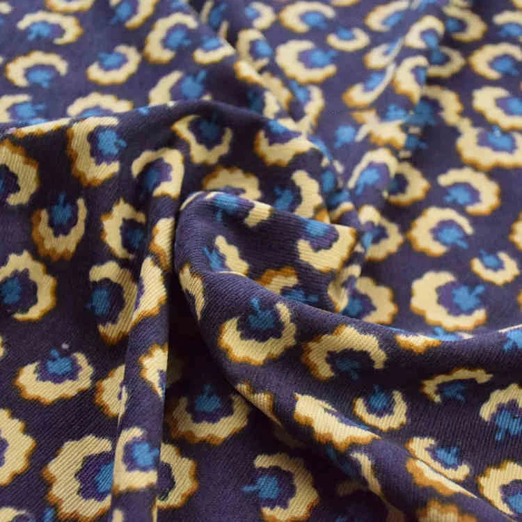Gros plan sur le Tissu velours côtelé à fleurs colorées de Longan Craft France, vendu au mètre, montrant les plis et la texture - idéal pour la couture, l'ameublement et les projets créatifs.
