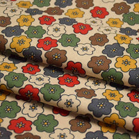 Un gros plan du tissu velours côtelé à fleurs colorées de Longan Craft France montre des fleurs à cinq pétales rouges, jaunes, vertes, brunes, blanches et bleues avec de petits centres sur du beige. Idéal pour les vêtements, la décoration et l'artisanat. Vendu au mètre.