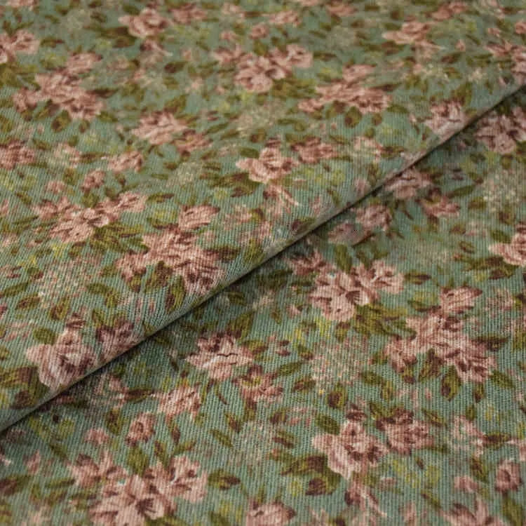 Le Tissu velours côtelé à fleurs colorées de Longan Craft France présente de petites fleurs roses pâles et des feuilles vertes sur fond vert doux, au mètre. Parfait pour la confection, l'ameublement ou les loisirs créatifs.