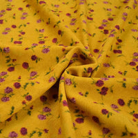 Tissu velours côtelé à fleurs colorées de Longan Craft France, vendu au mètre : motif floral jaune à petites fleurs rose et violette avec feuilles vertes, légèrement froissé pour une texture douce, idéal couture, ameublement et loisirs créatifs.