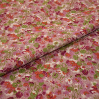 Gros plan sur le tissu velours côtelé à fleurs colorées au mètre de Longan Craft France, qui présente un tissu texturé et plié avec un motif floral vibrant en rose, vert, rouge et blanc, idéal pour la couture, l'ameublement et l'artisanat.