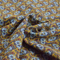 Gros plan sur le Tissu velours côtelé à fleurs colorées Longan Craft France, montrant son motif détaillé jaune, bleu et rouge avec une texture et des plis visibles - idéal pour la confection, l'ameublement et les loisirs créatifs.
