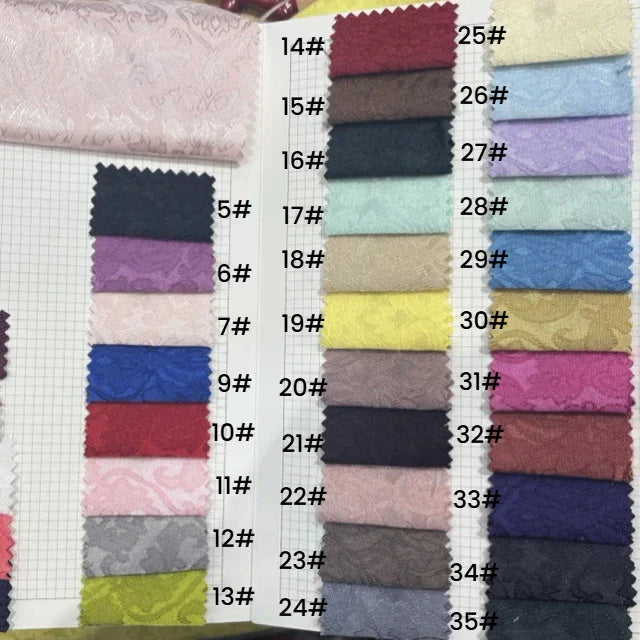 Le livre d'échantillons de tissu Longan Craft France présente 24 échantillons rectangulaires de tissu jacquard damassé, chacun étiqueté de 5# à 35#, dans des motifs floraux multicolores et d'élégants damas - idéal comme textile d'ameublement.