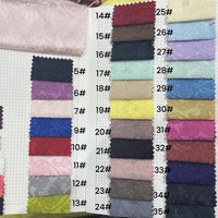 Le livre d'échantillons de tissu Longan Craft France présente 24 échantillons rectangulaires de tissu jacquard damassé, chacun étiqueté de 5# à 35#, dans des motifs floraux multicolores et d'élégants damas - idéal comme textile d'ameublement.