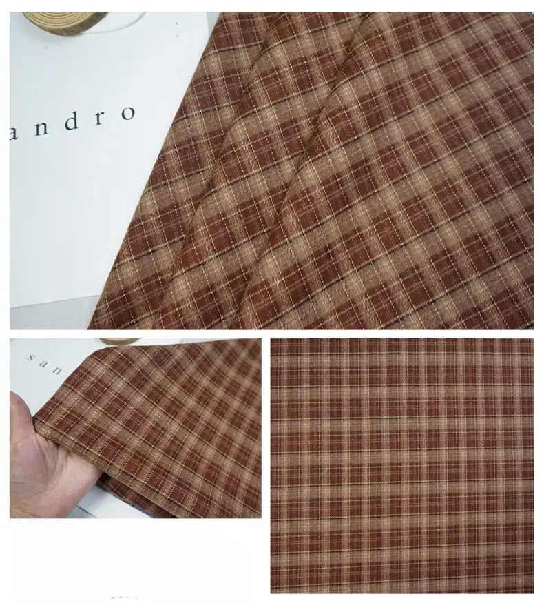 Le tissu écossais mammouth coloré de Longan Craft France, composé de polyester et de rayonne, est présenté plié et posé à plat. Ce tissu doux et brossé présente des carreaux classiques marron et beige, parfaits pour des projets de vêtements douillets.