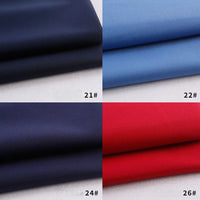 Quatre rectangles présentent la gabardine polyester épaisse Longan Craft France Tissu pliée en marine foncé (21#), bleu clair (22#), noir (24#) et rouge vif (26#) sur un fond blanc, mettant en valeur sa texture lisse et sa couleur riche.