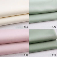 Quatre piles de tissu gabardine Longan Craft France pour les uniformes de bricolage sont présentées : blanc cassé (95#), vert clair (97#), rose pâle (98#) et vert sauge (99#). Chaque couleur est étiquetée avec son numéro.
