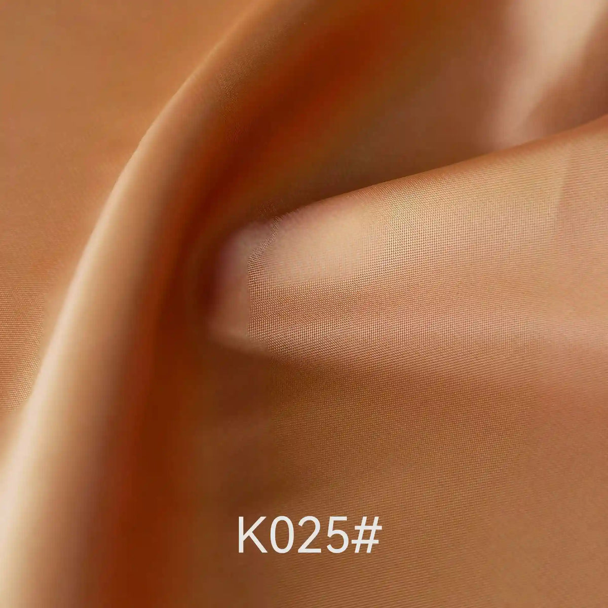 Gros plan sur un tissu satiné coloré en viscose au mètre de Longan Craft France, lisse et brillant, délicatement plié. Le code "K025#" figure en bas au centre. Idéal pour les robes élégantes et les occasions spéciales.