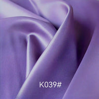 Gros plan sur un tissu satiné coloré en viscose au mètre de Longan Craft France, idéal pour robes de cérémonie, avec le code "K039#" affiché en bas au centre.