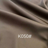 Tissu satiné en viscose marron lisse de Longan Craft France, avec un drapé doux et "K050#" en blanc au centre-tissu satiné coloré en viscose au mètre, idéal pour robes de cérémonie.