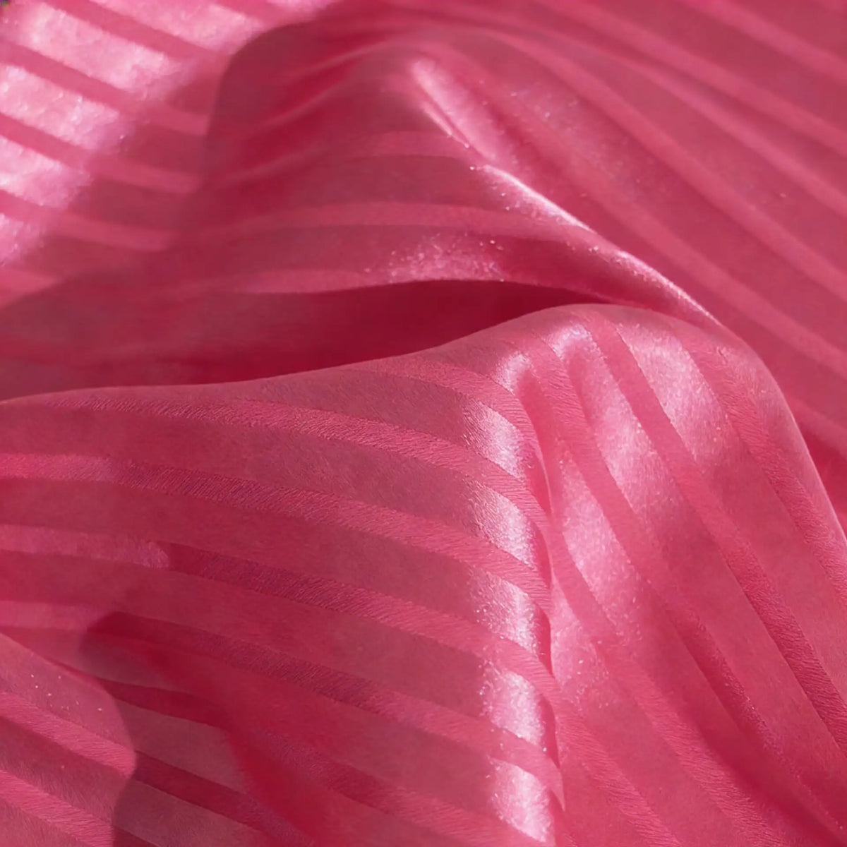 Découvrez le tissu satin jacquard rayé coloré au mètre de Longan Craft France : une matière satinée à motifs brillants, idéale pour la confection de robes élégantes, avec ses rayures horizontales mates et brillantes en rose translucide.