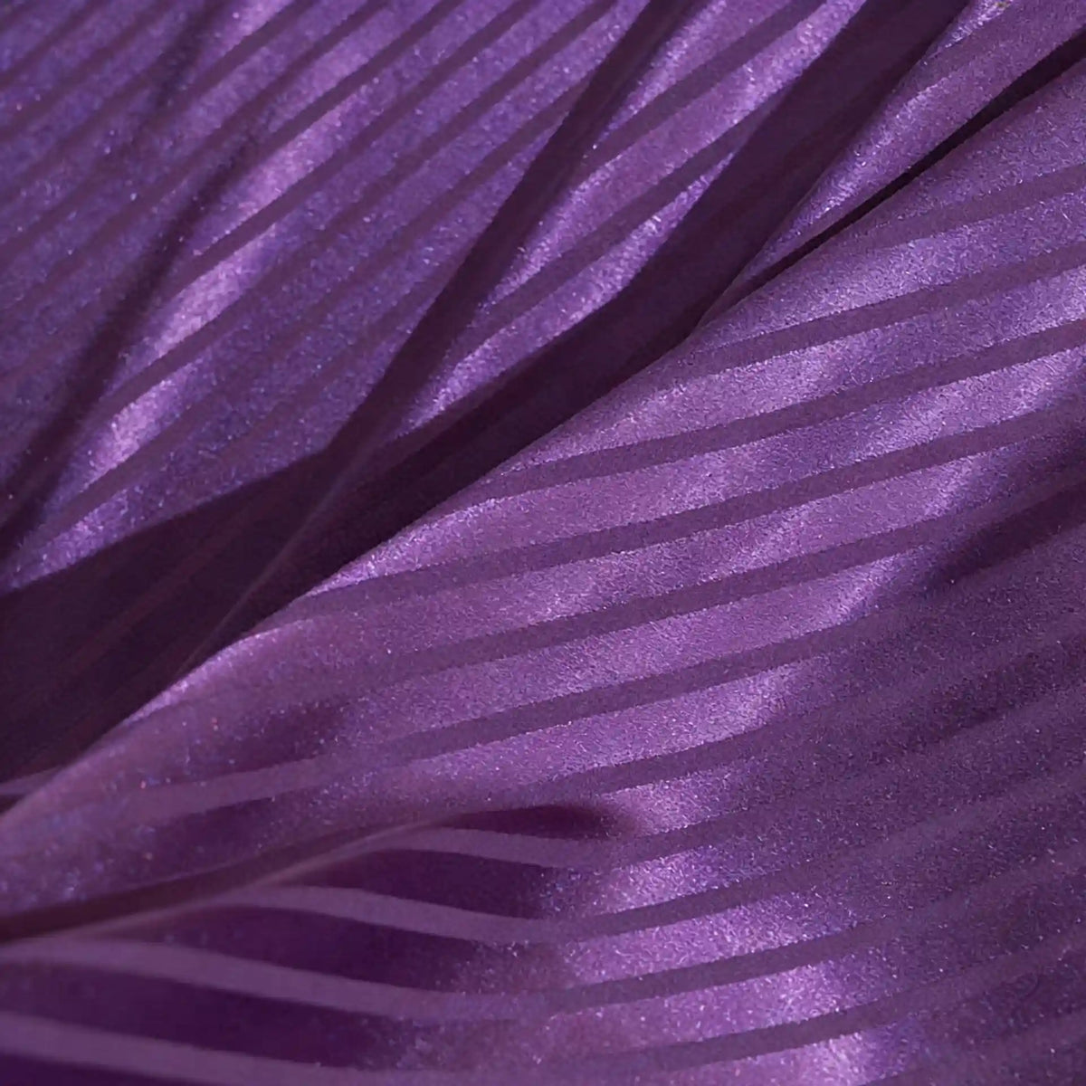 Gros plan sur le tissu satin jacquard rayé coloré au mètre de Longan Craft France, qui présente des rayures diagonales mates et brillantes. Ce tissu satiné doux et lisse est idéal pour les peignoirs, car il présente des plis élégants et des motifs chatoyants.