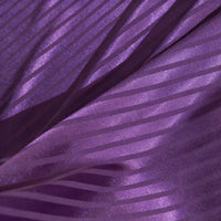 Gros plan sur le tissu satin jacquard rayé coloré au mètre de Longan Craft France, qui présente des rayures diagonales mates et brillantes. Ce tissu satiné doux et lisse est idéal pour les peignoirs, car il présente des plis élégants et des motifs chatoyants.