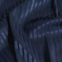 Un gros plan du tissu satin jacquard rayé coloré au mètre de Longan Craft France montre des rayures verticales subtilement brillantes et mates, avec des plis doux et une légère brillance - une matière satinée idéale pour la confection de robes.