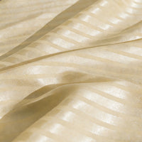 Gros plan sur le Tissu satin jacquard rayé coloré au mètre de Longan Craft France, qui présente des rayures diagonales chatoyantes de couleur crème et des plis souples - une matière satinée parfaite pour la confection de robes.