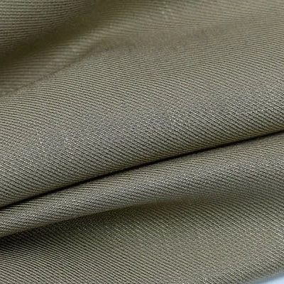Gros plan sur le tissu lyocell sergé kaki plié de Longan Craft France, qui présente une armure sergée diagonale visible et de fines lignes texturées. Fabriqué à partir de 100% de lyocell durable, idéal pour des costumes confortables et durables.