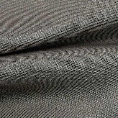 Gros plan sur un morceau plié de Tissu lyocell sergé coloré de Longan Craft France, un textile 100% lyocell durable et confortable, au motif finement nervuré, idéal pour costumes. Les plis révèlent sa texture douce et serrée.