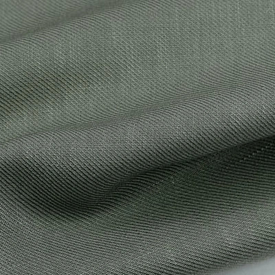 Gros plan sur le tissu lyocell sergé gris-vert coloré au mètre de Longan Craft France. Ce textile durable 100 % lyocell présente un tissage visible et des plis souples, idéal pour des costumes confortables et élégants.