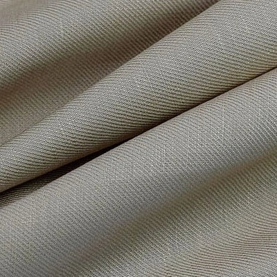 Un gros plan sur le tissu lyocell sergé beige plié de Longan Craft France montre sa texture lisse et son subtil motif à chevrons diagonaux. Tissu lyocell 100 % durable, vendu au mètre, idéal pour des costumes confortables.