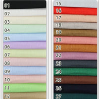 Une photo présente 27 échantillons du tissu en viscose challis multicolore de Longan Craft France, disposés en deux colonnes verticales. Chaque échantillon numéroté présente une couleur unique de ce léger tissu en viscose-polyester destiné aux chemises de protection solaire.