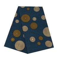 Un morceau rectangulaire de Longan Craft France Tissu wax africain Ankara, bleu foncé avec de grands et petits cercles concentriques dorés régulièrement espacés, idéal pour les styles vestimentaires à la mode.