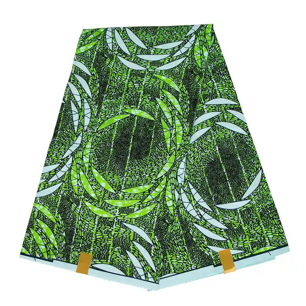Un morceau plié de Tissu wax africain Ankara coloré au mètre par Longan Craft France, avec un motif géométrique abstrait vert, noir et blanc composé de lignes et de formes courbes qui se chevauchent, présenté sur un fond blanc.