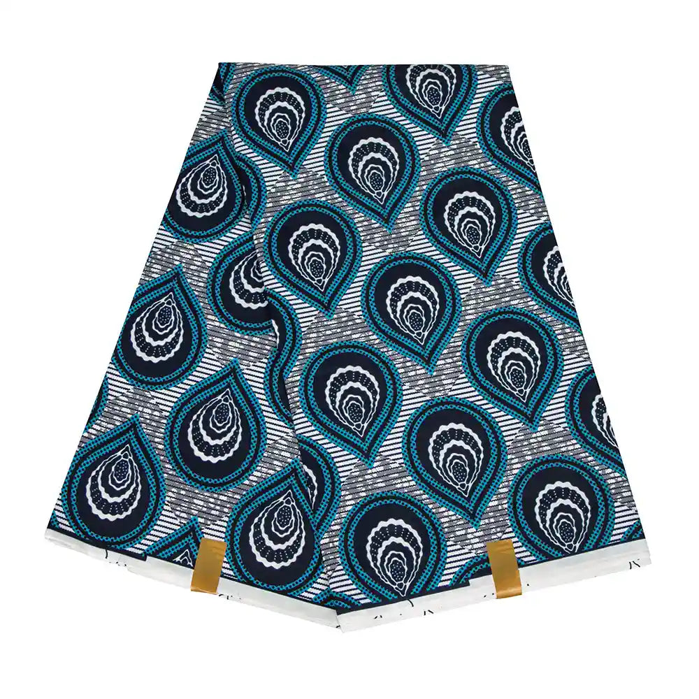 Un morceau plié de Longan Craft France Tissu wax africain Ankara coloré avec des motifs bleus, noirs et blancs en forme de gouttes, avec des clips dorés à la base pour maintenir le tissu en place. Textile tendance pour différents styles vestimentaires.