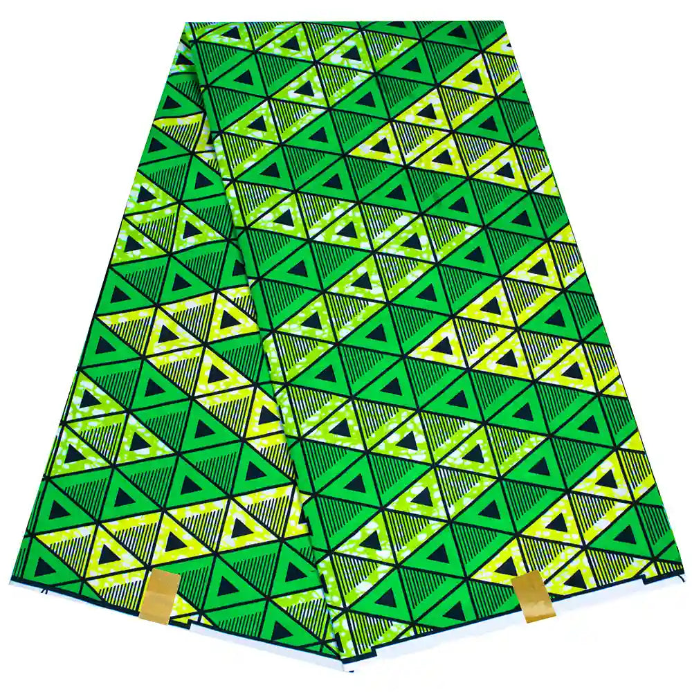 Un morceau plié de Tissu wax africain Ankara coloré par Longan Craft France présente des triangles géométriques verts, jaunes et noirs en rangées, avec deux étiquettes jaunes sur le bord inférieur - parfait pour les styles vestimentaires à la mode.
