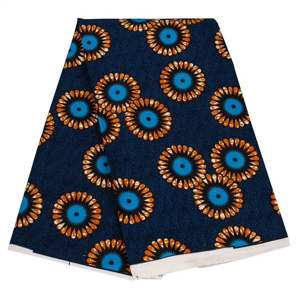 Un morceau plié de Tissu wax africain Ankara coloré au mètre par Longan Craft France, avec un fond bleu foncé et des motifs floraux orange, bleus et noirs éclatants, met en valeur le textile Ankara très tendance pour divers styles de vêtements.