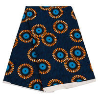 Un morceau plié de Tissu wax africain Ankara coloré au mètre par Longan Craft France, avec un fond bleu foncé et des motifs floraux orange, bleus et noirs éclatants, met en valeur le textile Ankara très tendance pour divers styles de vêtements.